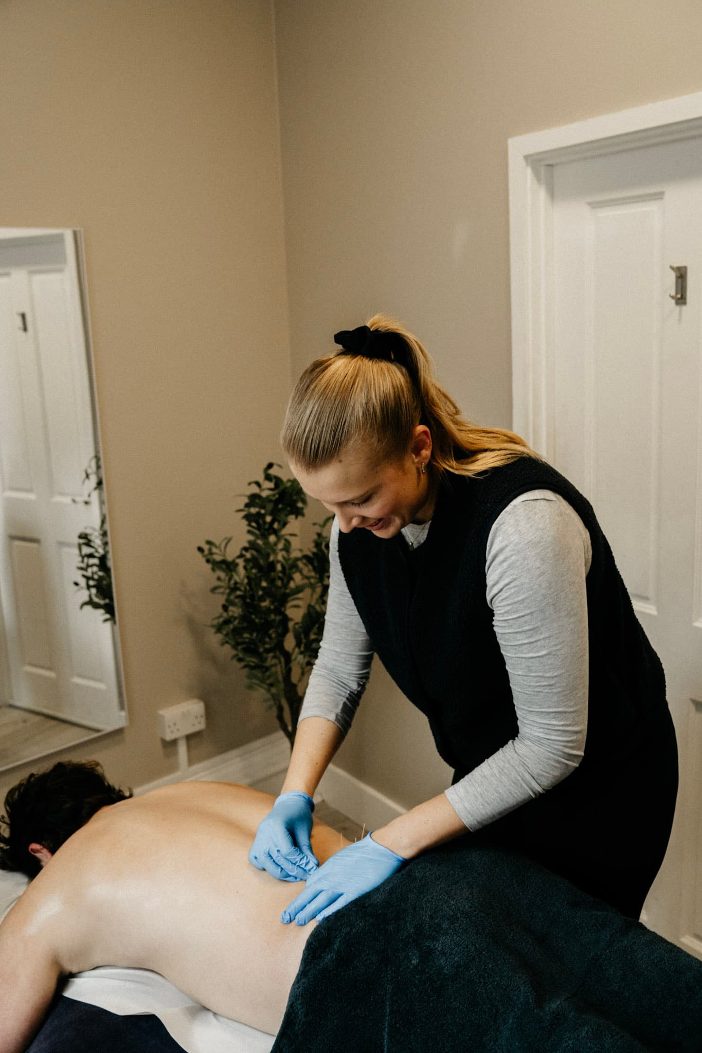 Physiotherapist performing dry needling on a client's back