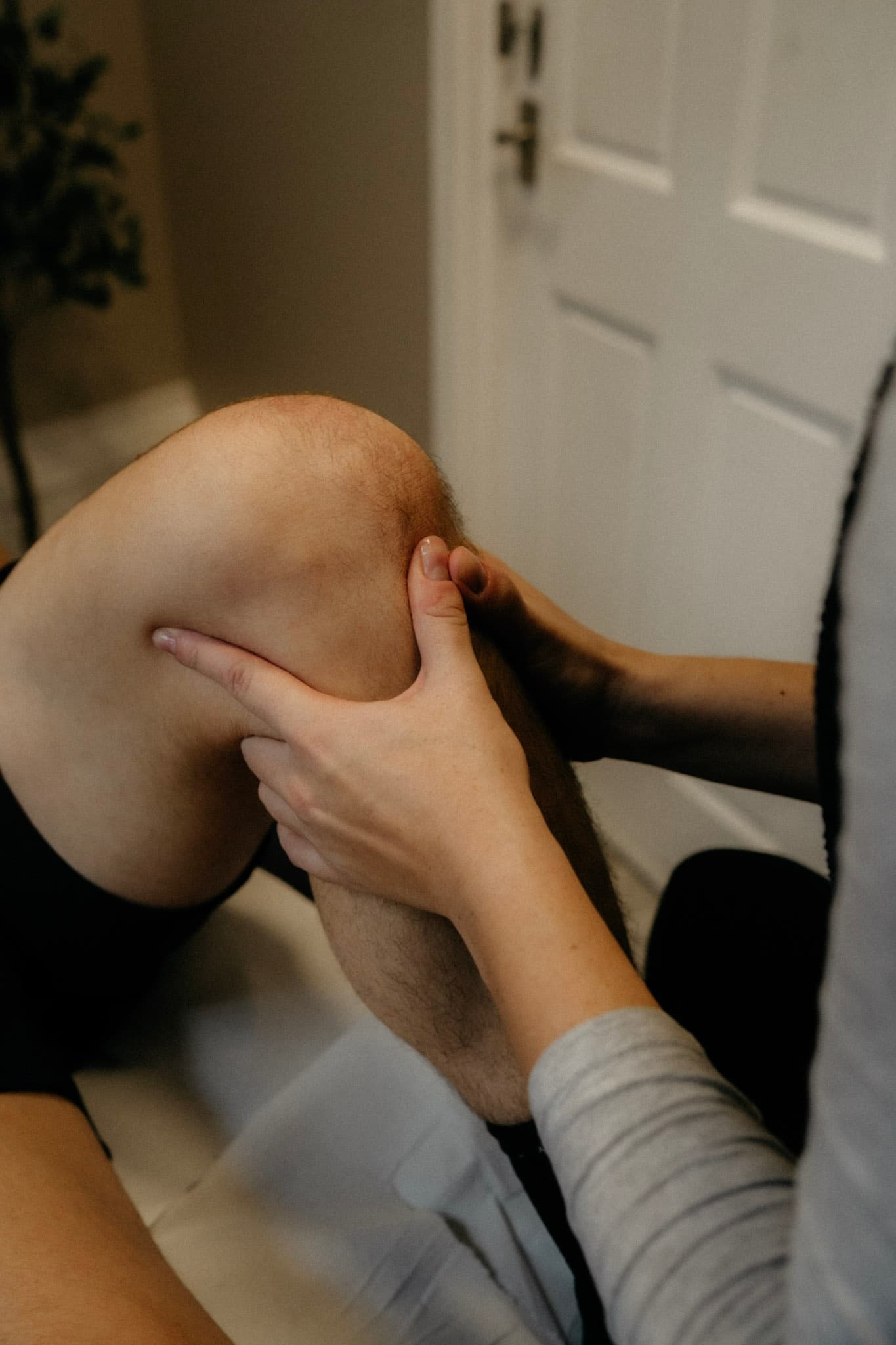 Close-up of a physiotherapist assessing a client's bent knee