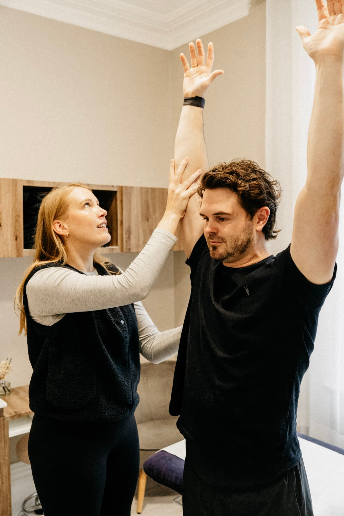 Physiotherapist assessing a client's shoulder range of motion
