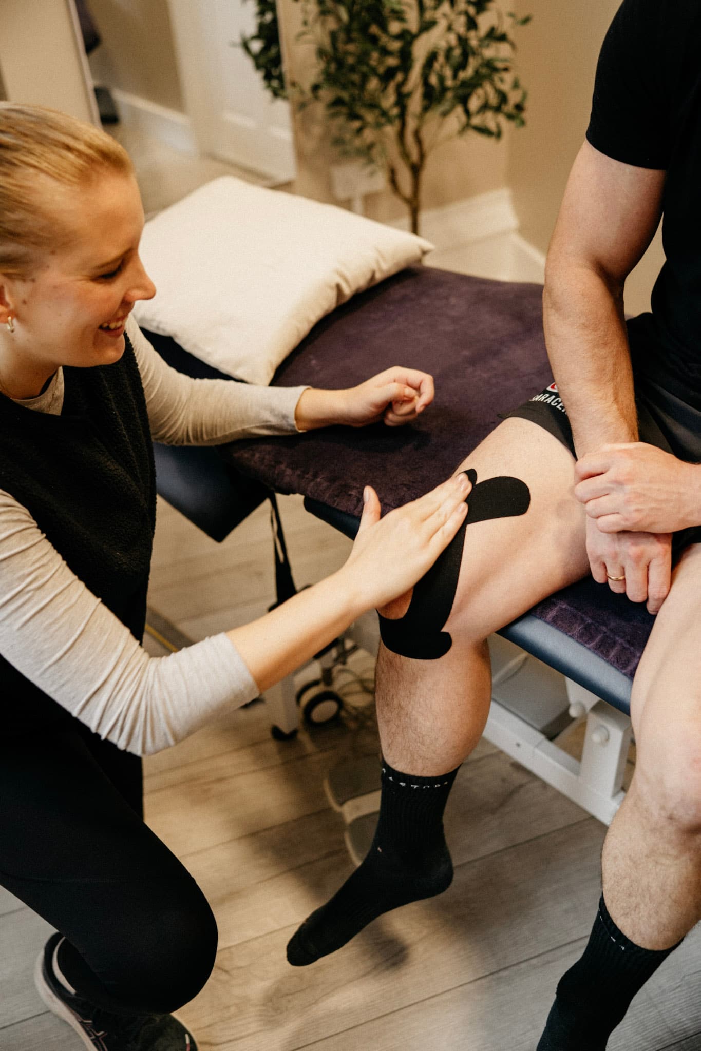 Close-up of a physiotherapist's hands performing soft tissue massage on a client's back